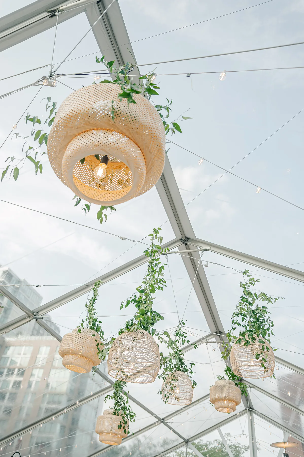 Pendant light and greenery detail inside a clear-top tent