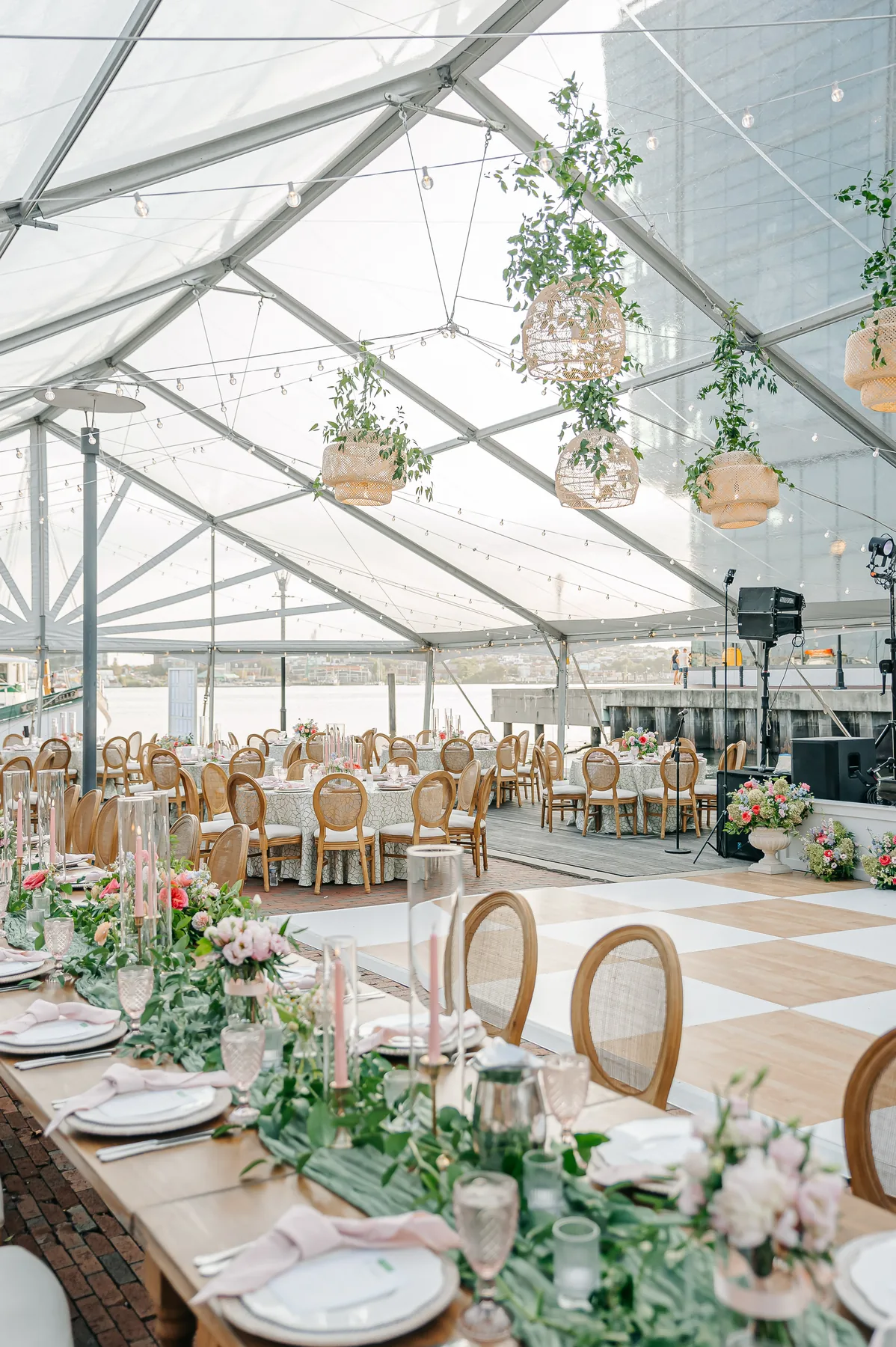 Wedding reception tables inside a clear-top tent