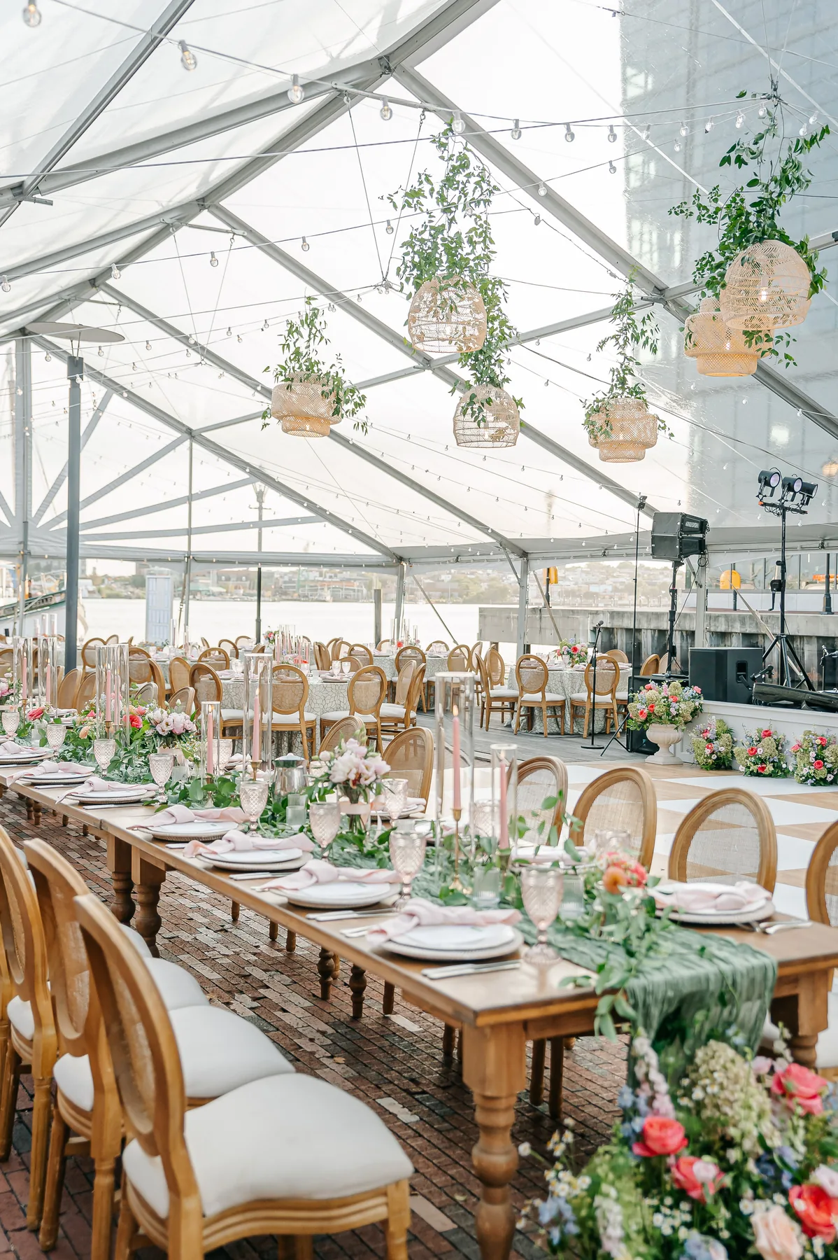 Long wedding table set beneath a clear-top tent