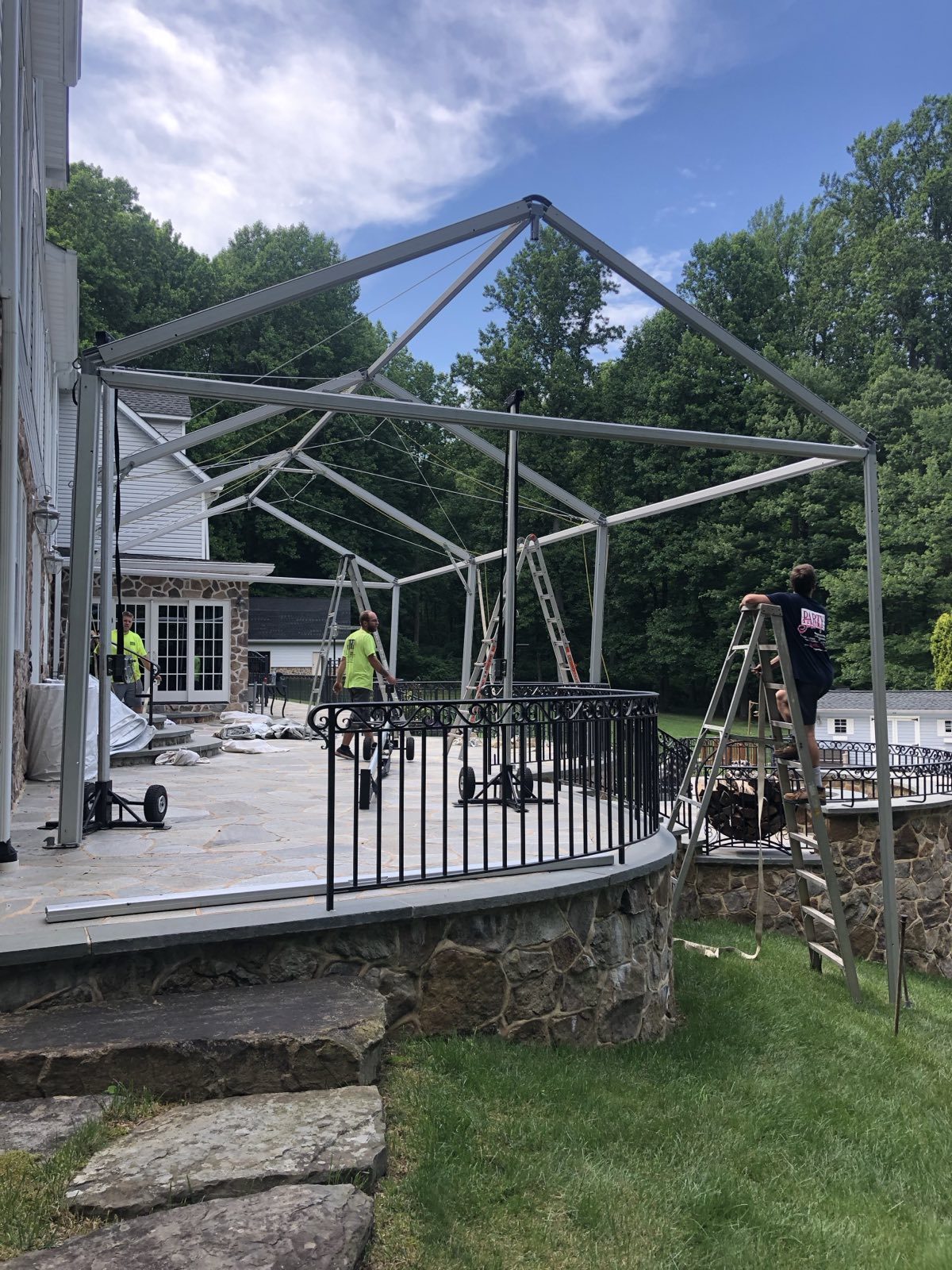 Crew installing a tent frame over a deck