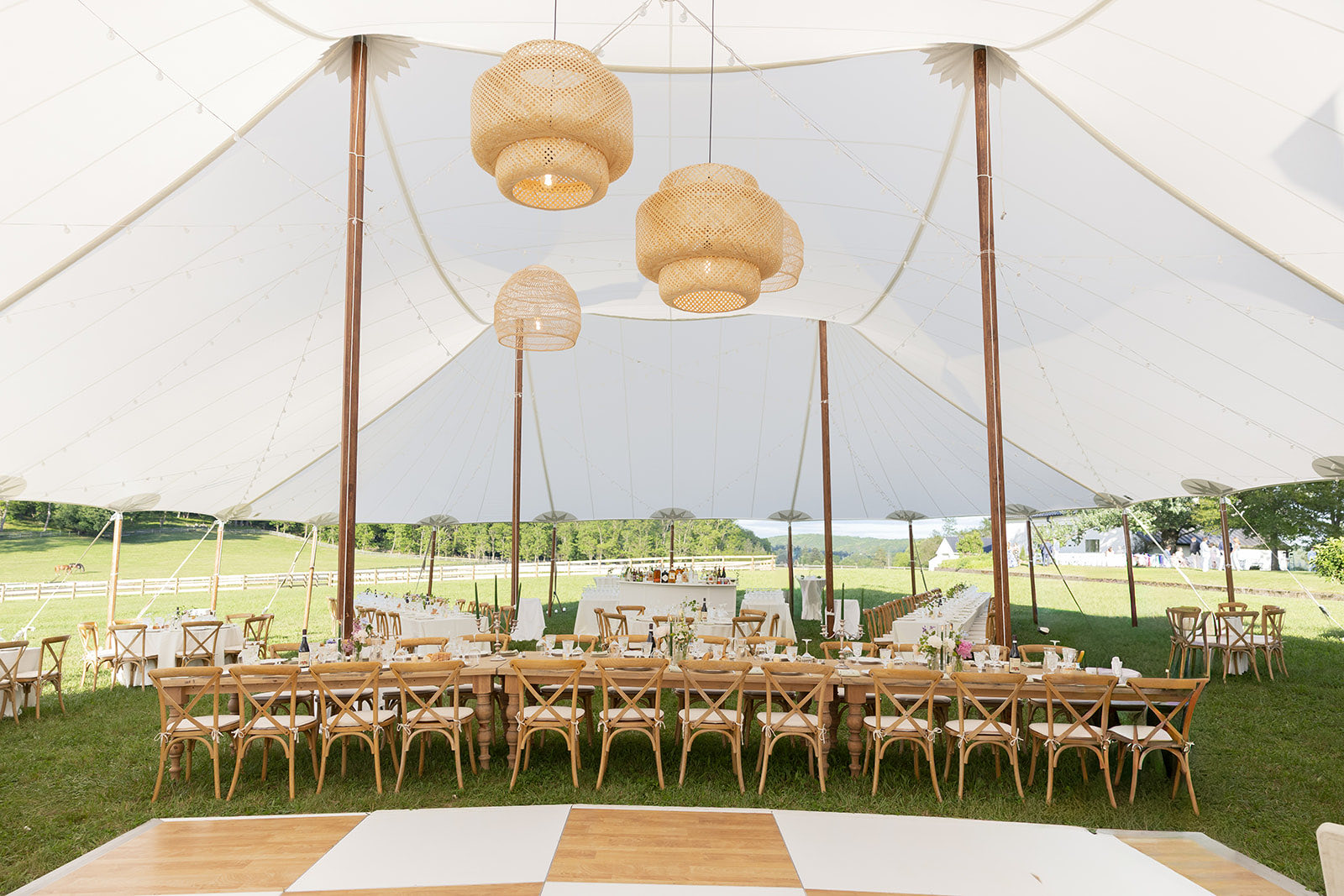 Cross-back chairs and checkerboard dance floor in a sailcloth tent
