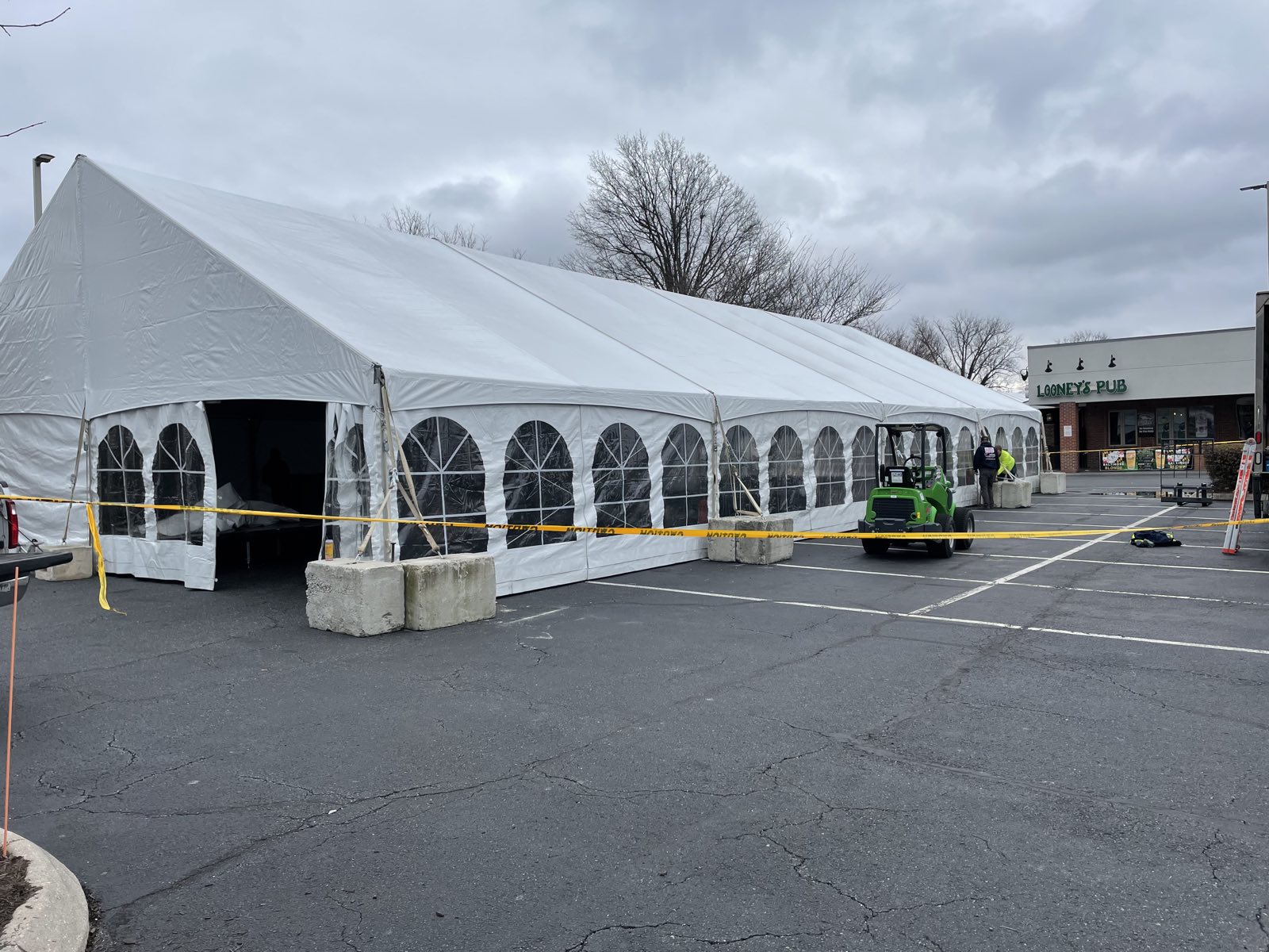 Frame tent installation in progress with forklift on site