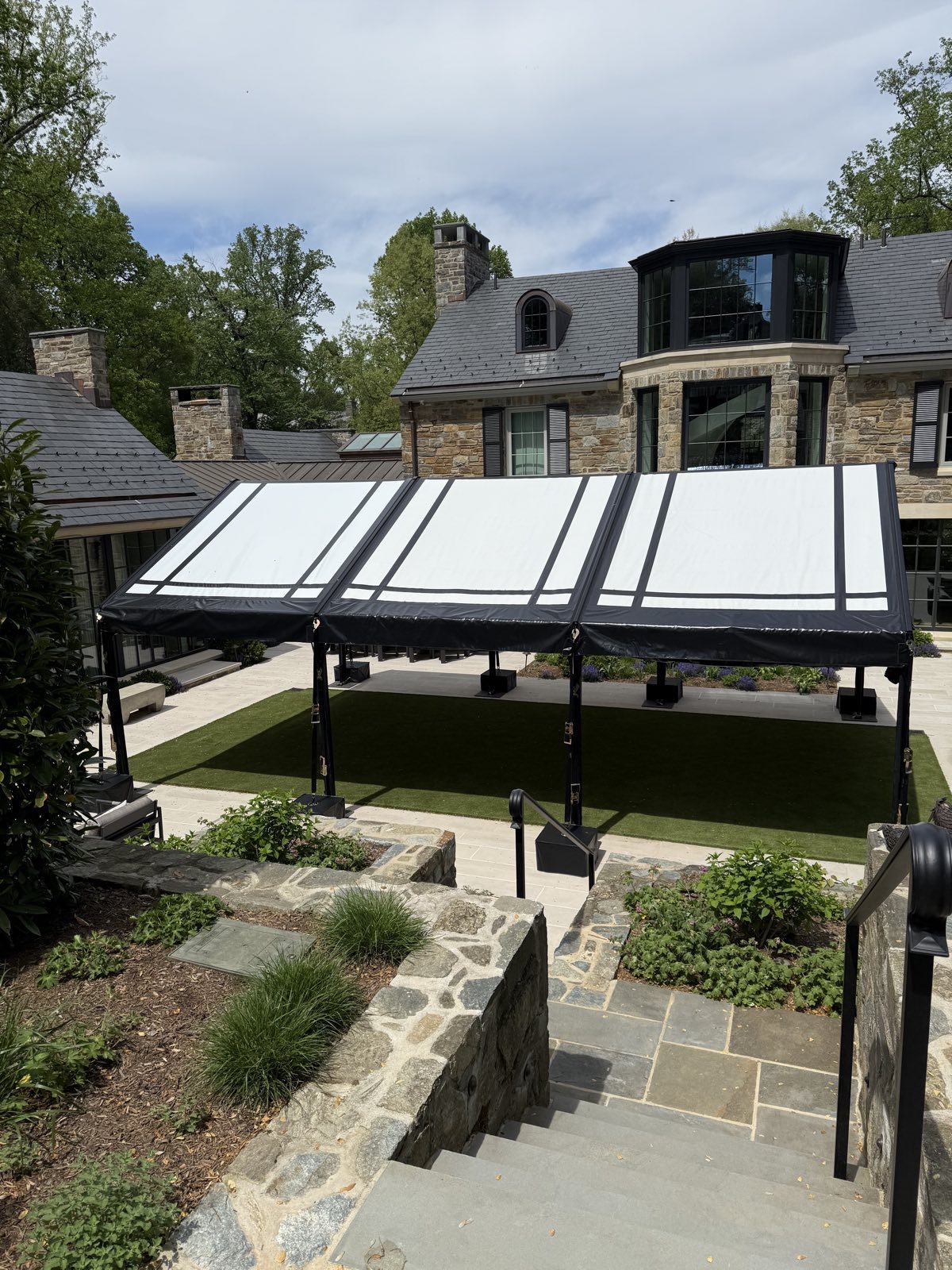 Pergola frames with white tops beside an estate pool