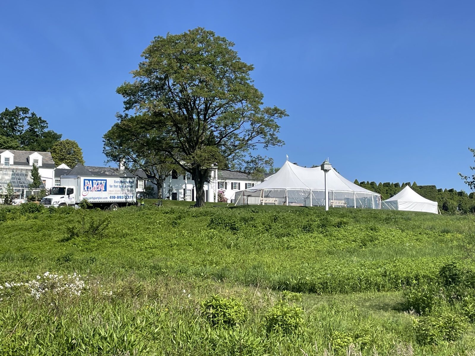 Sailcloth tent in a meadow with the delivery truck on site