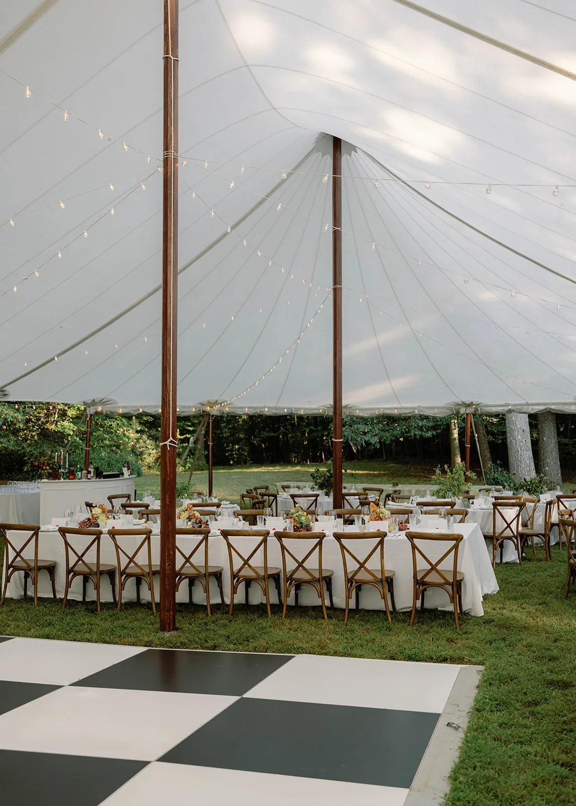 Long reception tables inside a sailcloth wedding tent