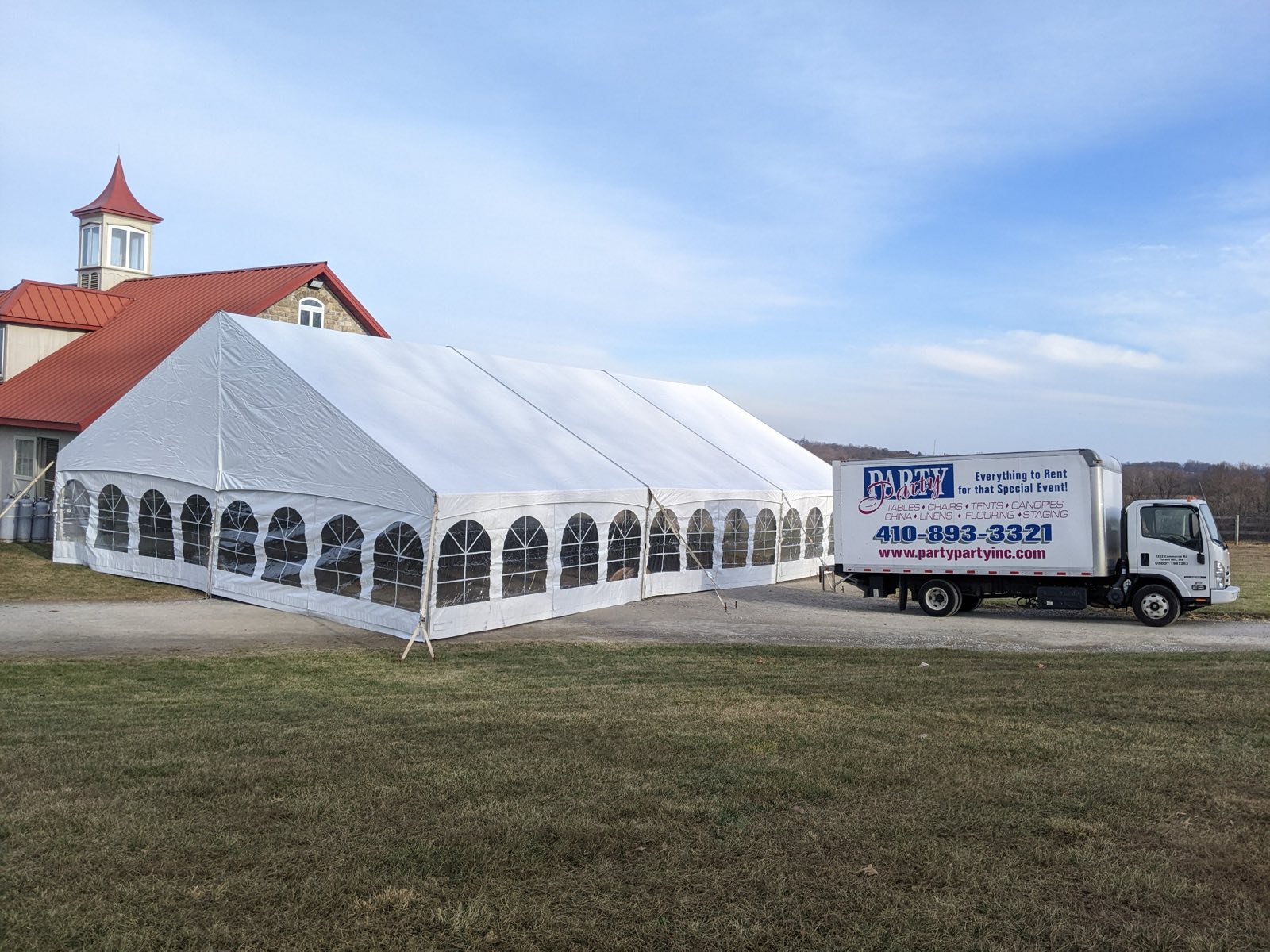 Structure tent and delivery truck at a red barn