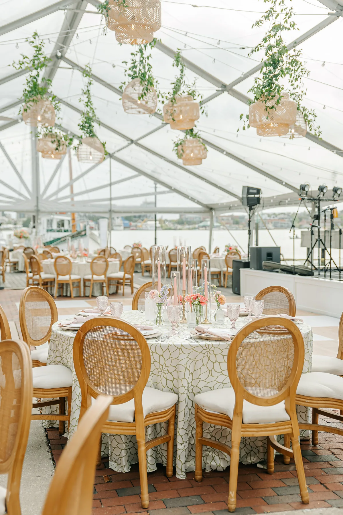 Wedding tables and floral arrangements inside a clear-top tent