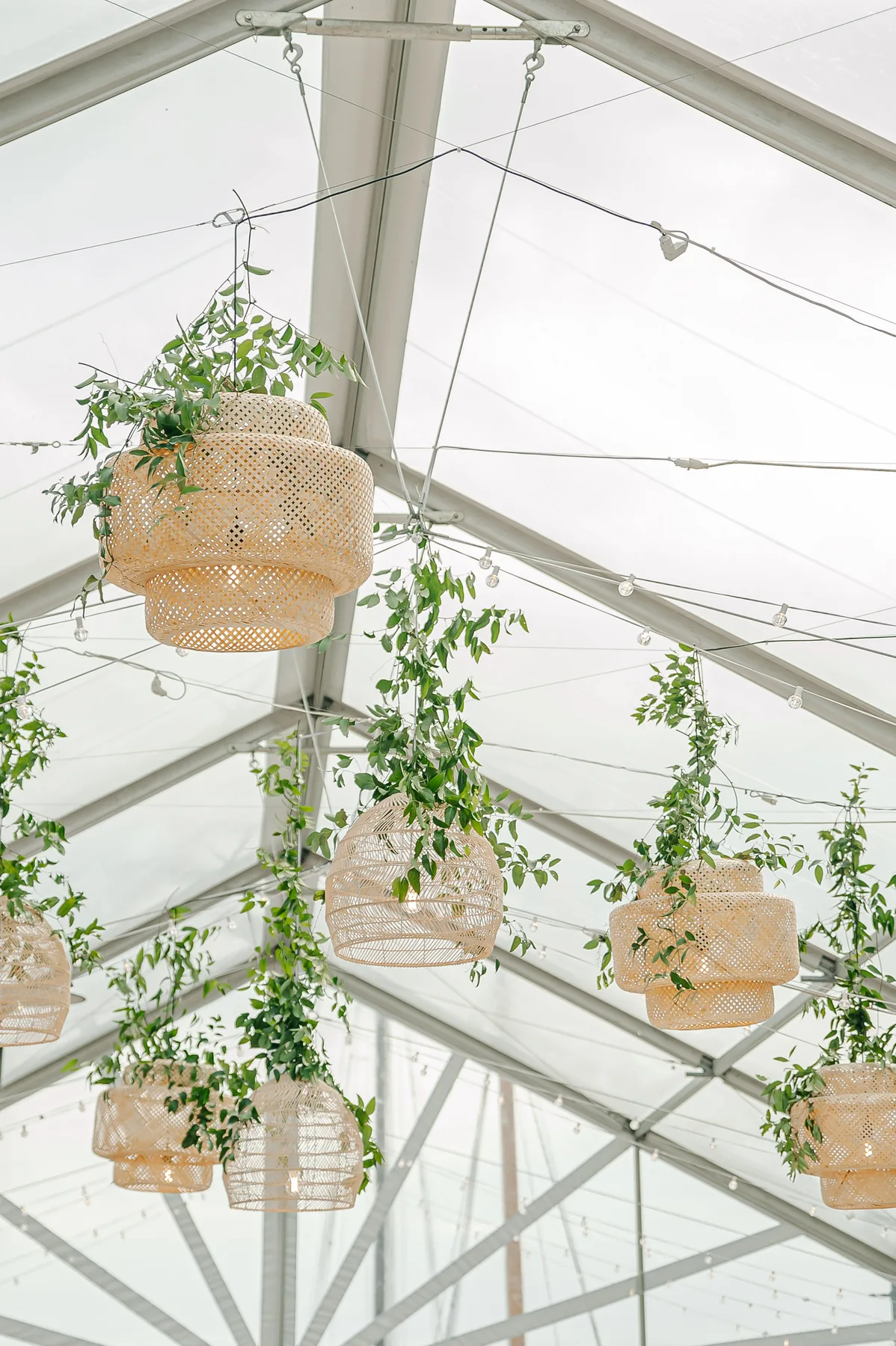 Woven pendant lights hanging inside a clear-top tent