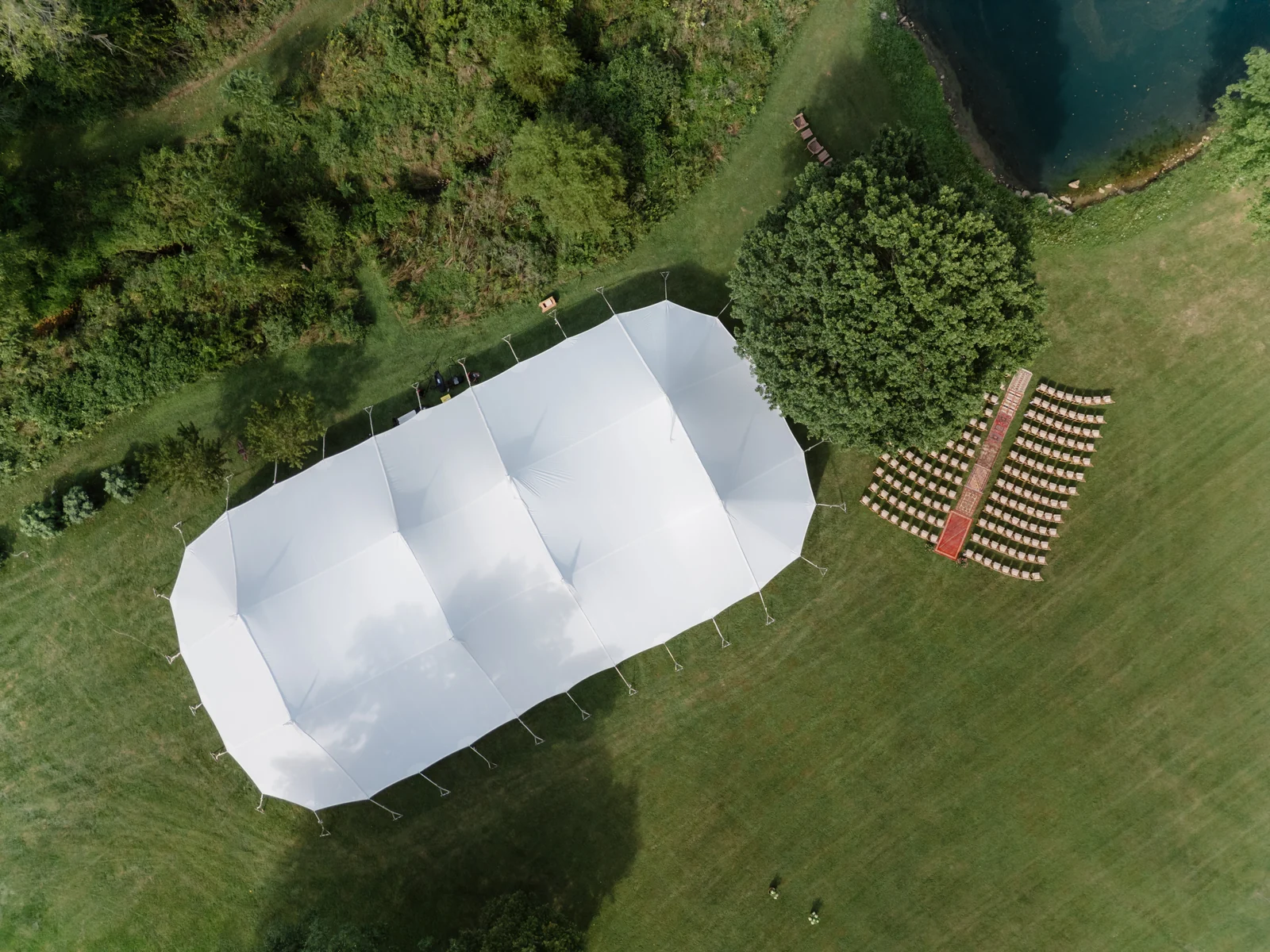 Overhead view of a sailcloth wedding tent and rows of outdoor ceremony chairs